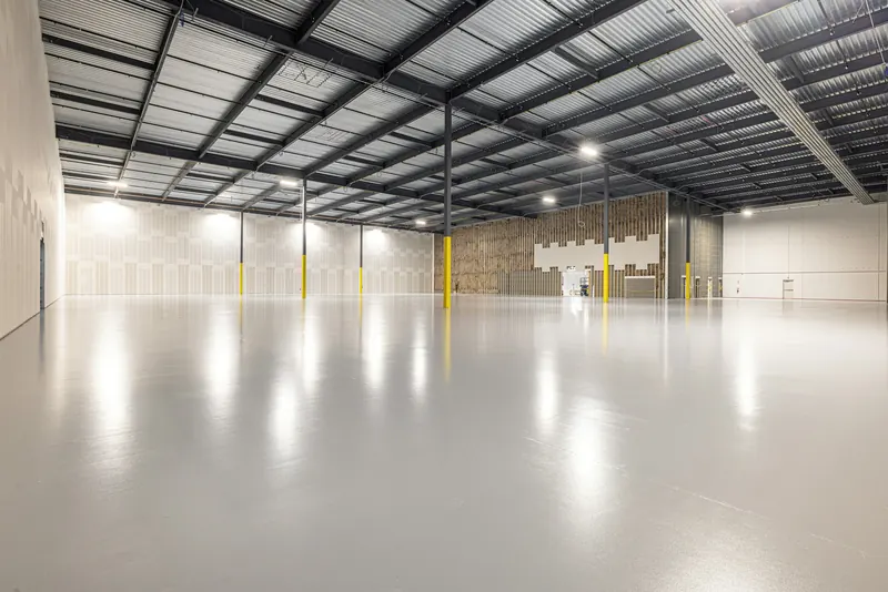 Leere Industriehalle mit hellem, glänzendem Betonboden
